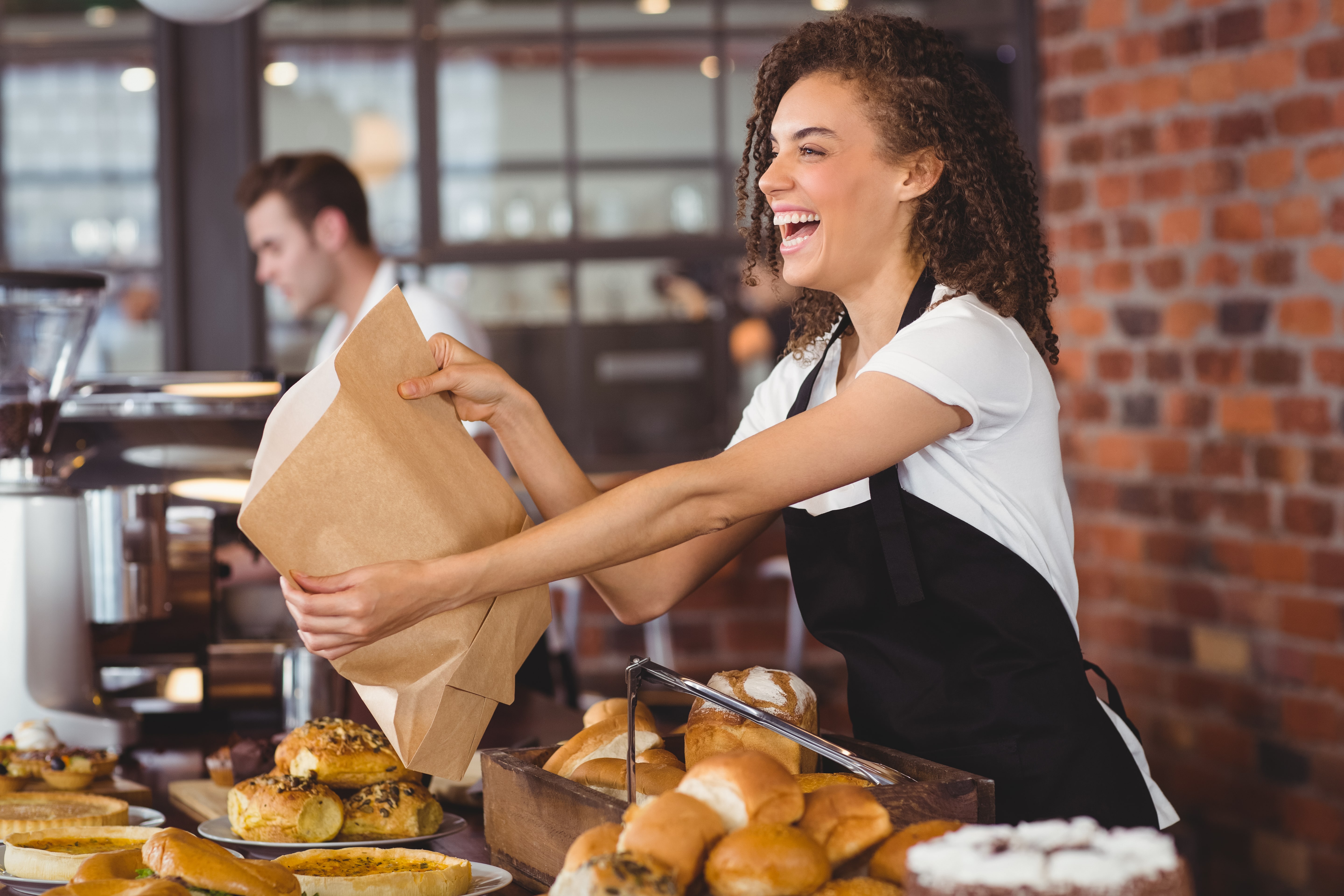 Smiling,Waitress,Giving,Paper,Bag,To,Customer,At,Coffee,Shop