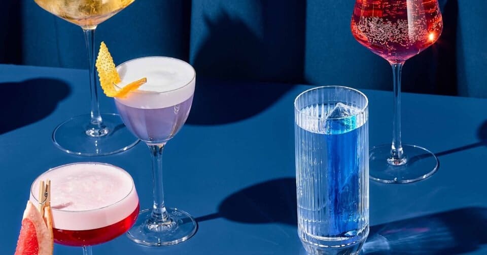 Composition,With,Alcohol,Cocktails,On,Coloured,Background,With,Harsh,Shadows.